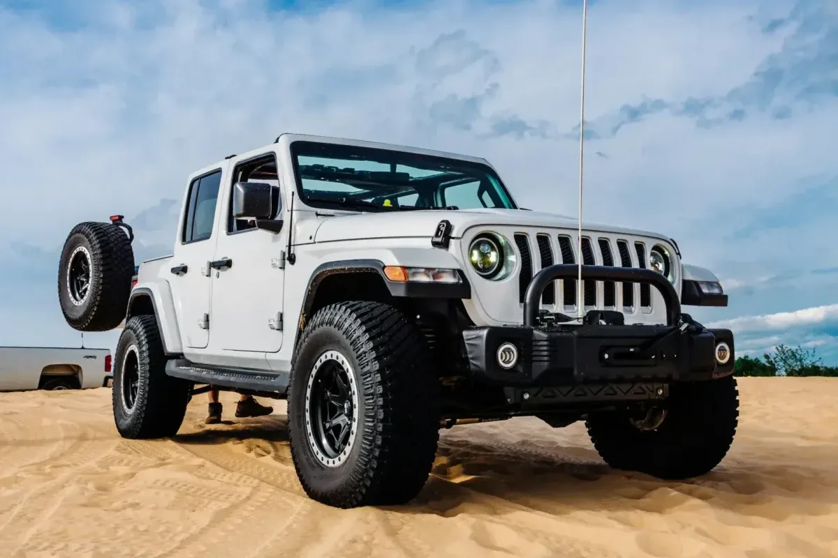 a white jeep with a flag on top of it